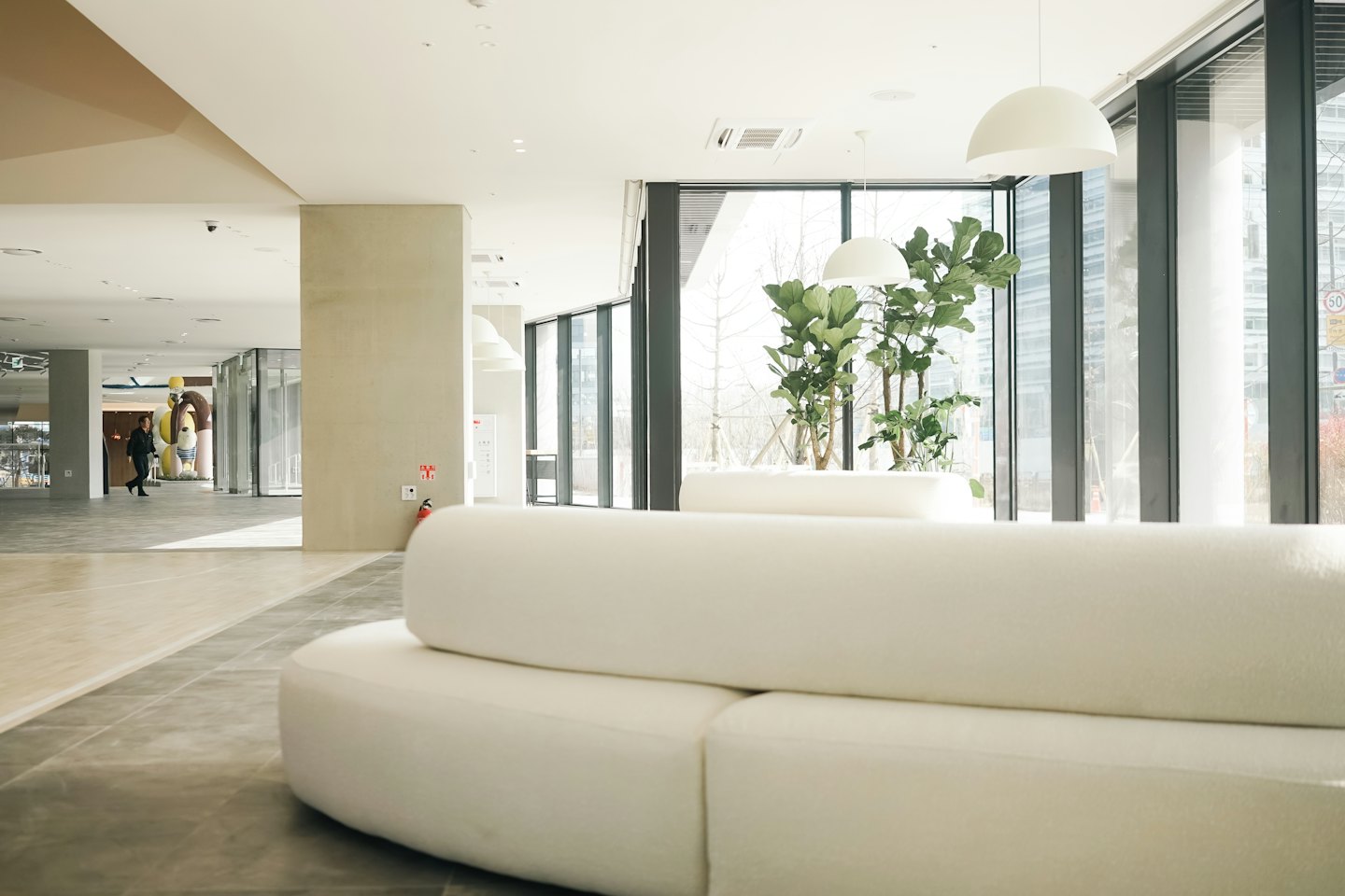 Moderne Lobby mit geschwungenen Sofas und großen Fenstern.